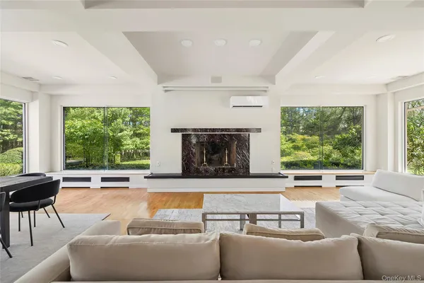 a living room with furniture fireplace and large windows