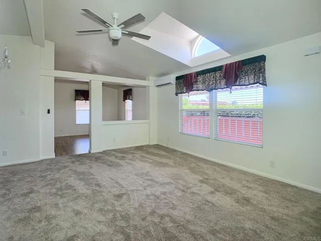 en empty room with windows and ceiling fan