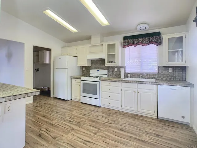 a kitchen with granite countertop a sink stainless steel appliances and cabinets