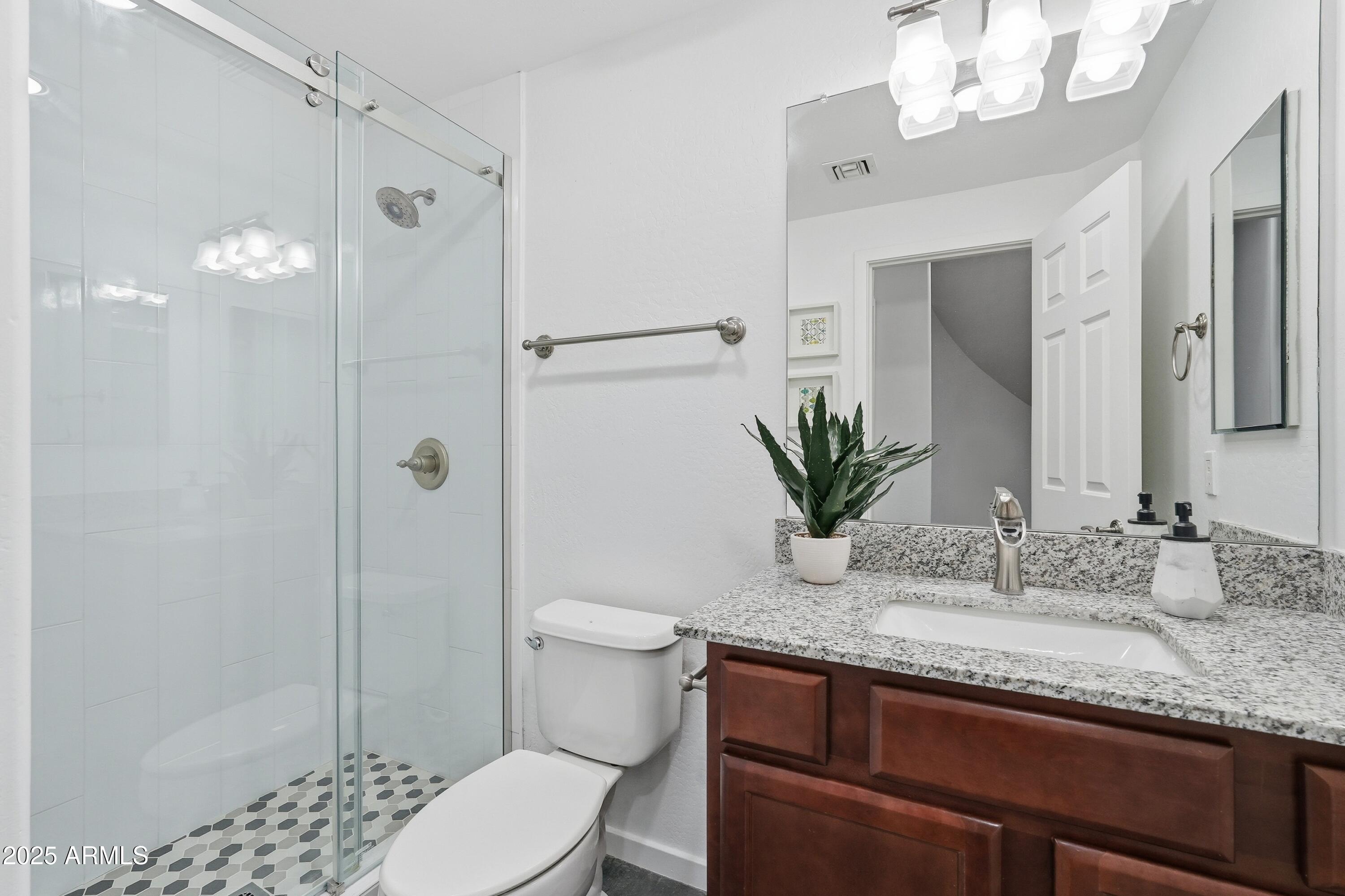 3935 East Rough Rider Road, Unit 1140 Phoenix, AZ 85050 - Photo 12 of 24 a bathroom with a granite countertop sink a toilet and shower
