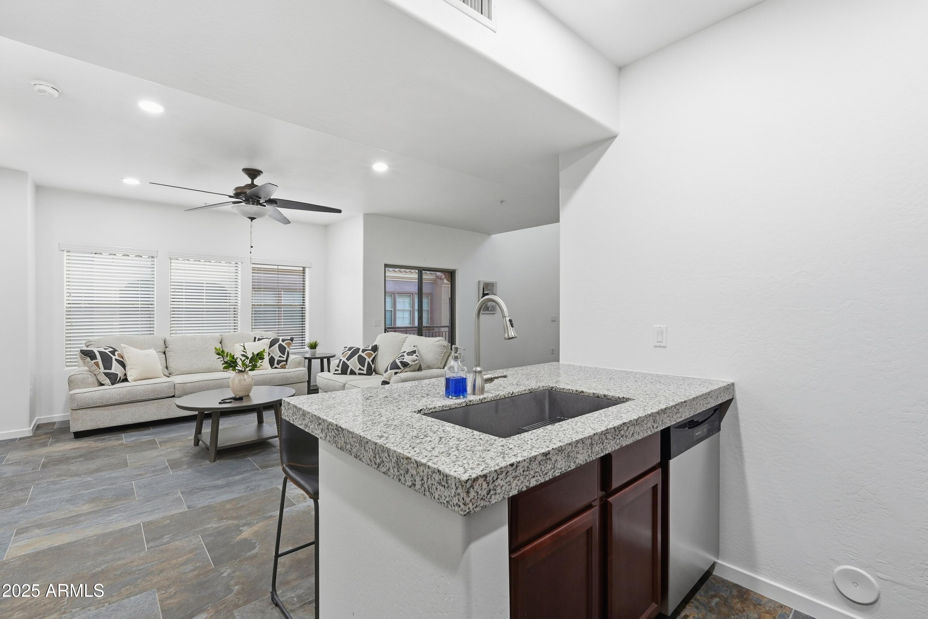 3935 East Rough Rider Road, Unit 1140 Phoenix, AZ 85050 - Photo 4 of 24 a kitchen with granite countertop a sink and a stove