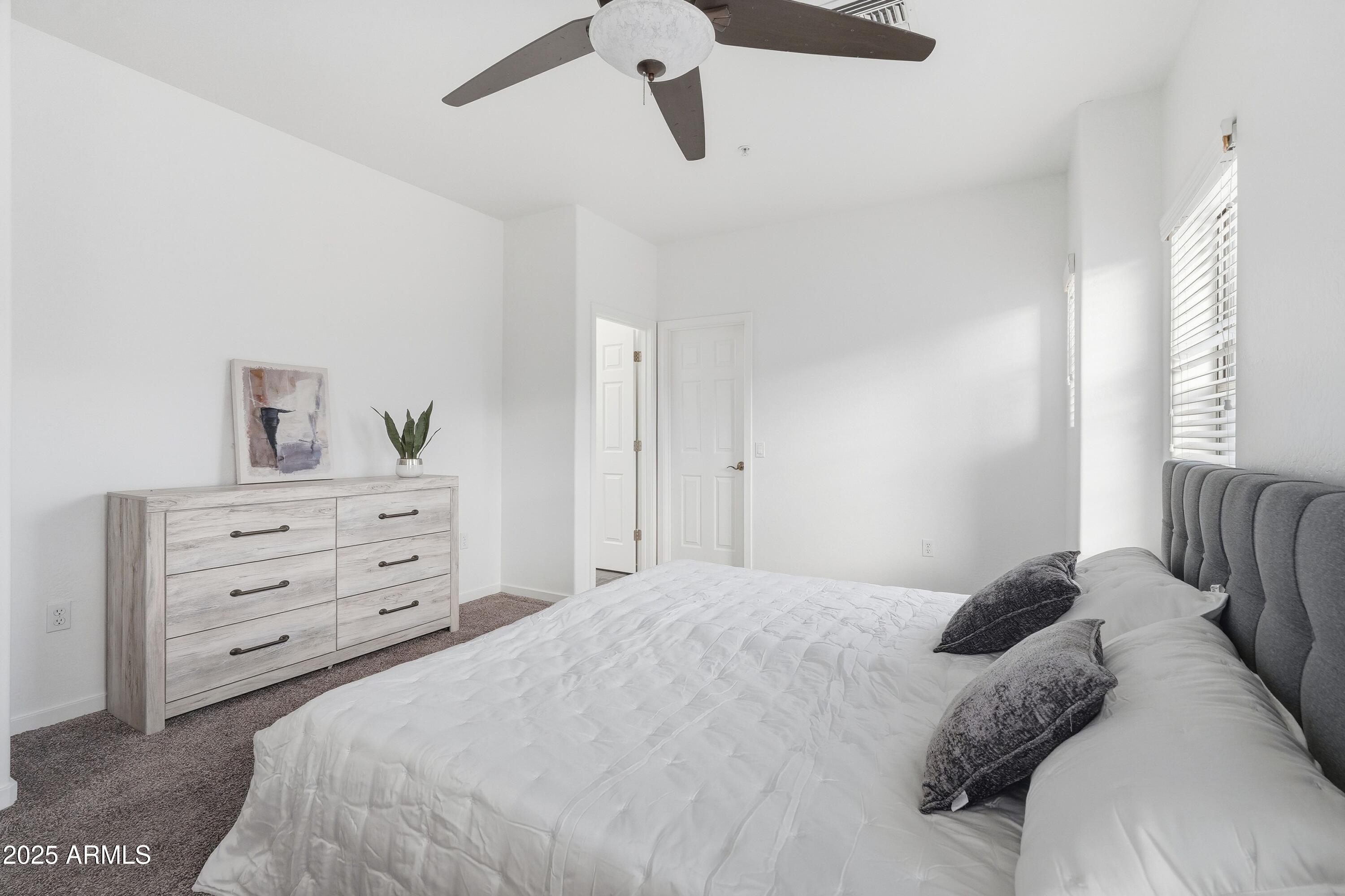 3935 East Rough Rider Road, Unit 1140 Phoenix, AZ 85050 - Photo 9 of 24 a bedroom with a bed and a dresser