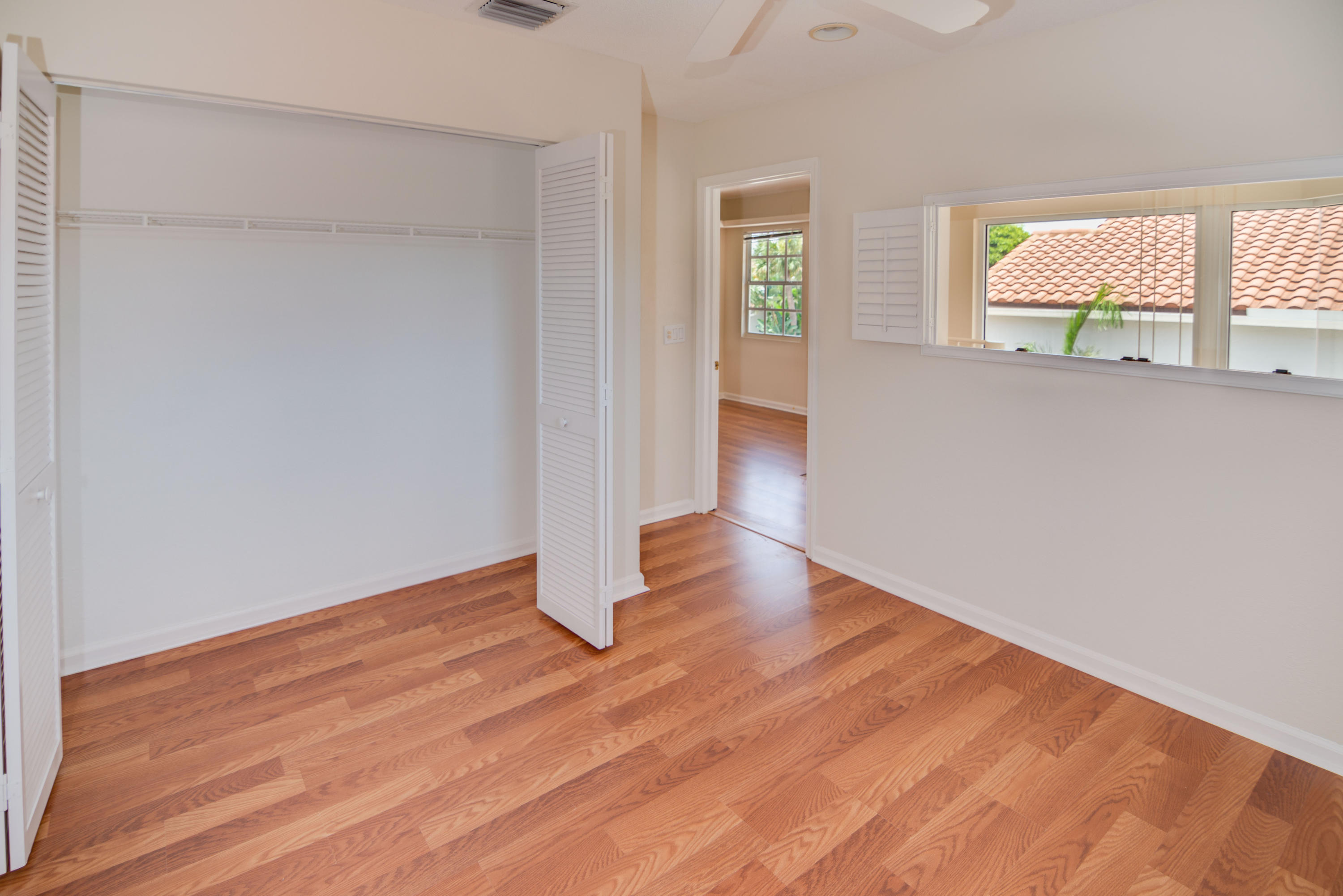 23177 Via Stel Boca Raton, FL 33433 - Photo 25 of 34 an empty room with wooden floor and windows