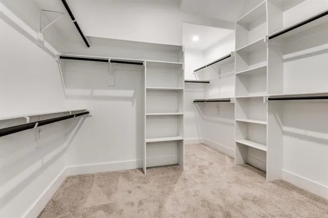 a view of walk in closet with empty racks