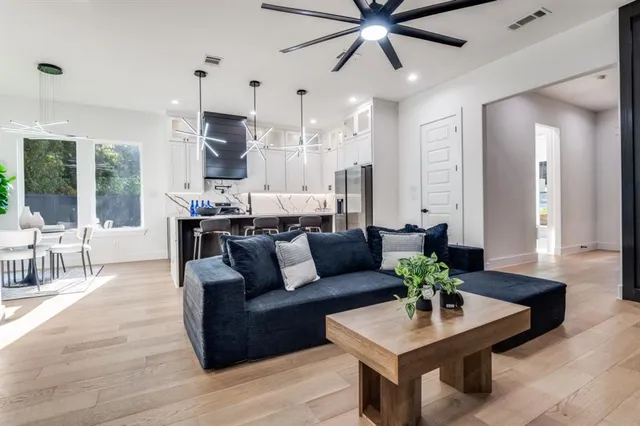 a living room with furniture kitchen view and a large window