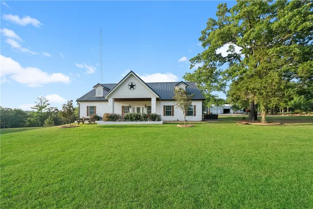 a front view of a house with a yard and trees