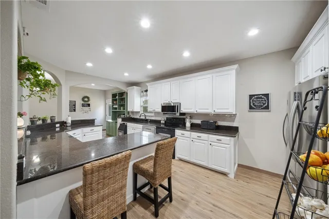 a kitchen with stainless steel appliances granite countertop a stove a sink and a microwave