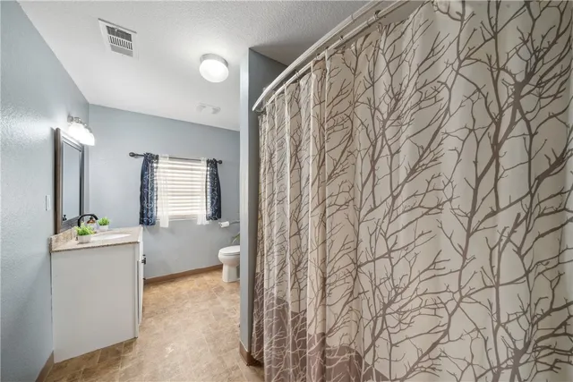 a spacious bedroom with a bed a couch and dresser