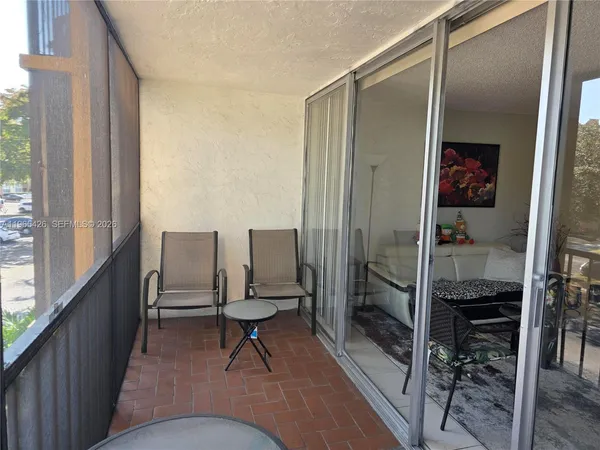 a view of a patio with table and chairs and floor to ceiling window
