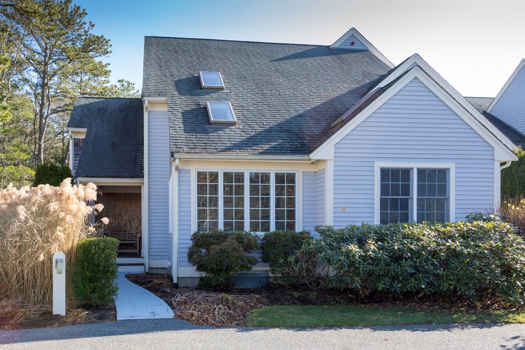 a view of a brick house with plants and large windows