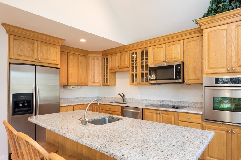 64 Gold Leaf Lane, Unit 64 Mashpee, MA 02649 - Photo 7 of 28 a kitchen with stainless steel appliances granite countertop a sink microwave and cabinets