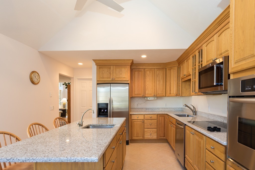 64 Gold Leaf Lane, Unit 64 Mashpee, MA 02649 - Photo 8 of 28 a kitchen with granite countertop a sink a stove top oven a refrigerator cabinets and living room view