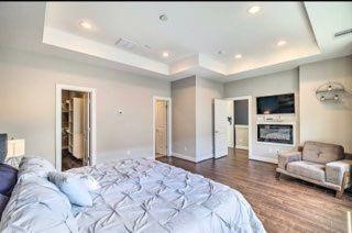 2403 Everett Street, Unit C Houston, TX 77009 - Photo 9 of 11 a spacious bedroom with a large bed a couch and chandelier