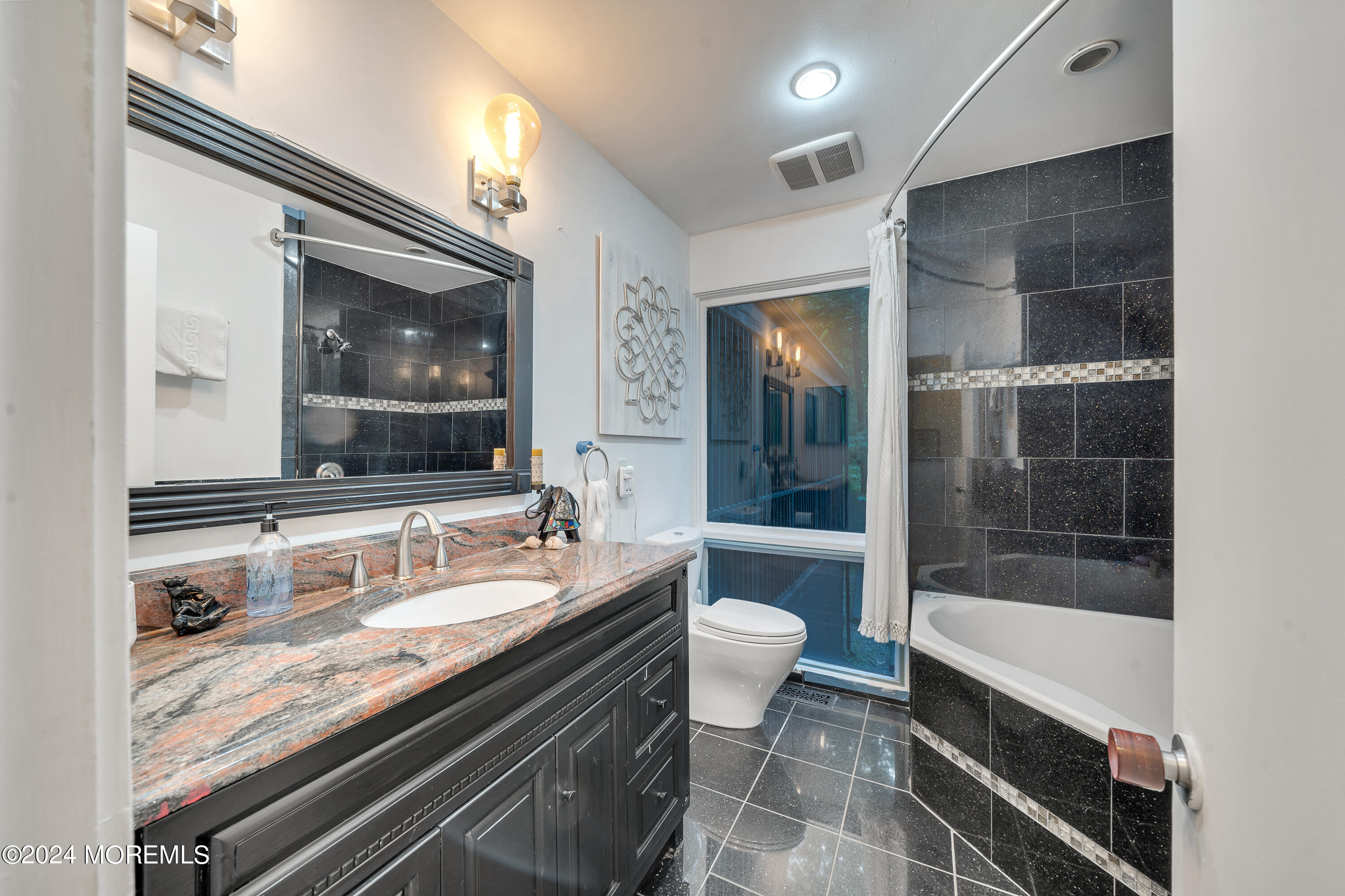 77 Telegraph Hill Road Holmdel, NJ 07733 - Photo 21 of 31 a bathroom with a granite countertop sink a toilet a mirror and shower