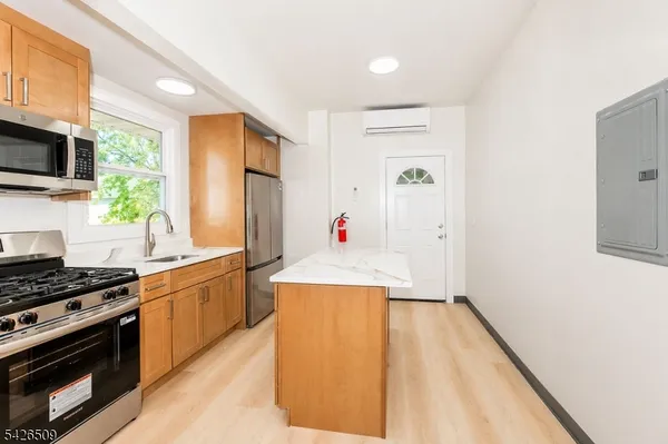 a kitchen with stainless steel appliances a stove a sink and a refrigerator