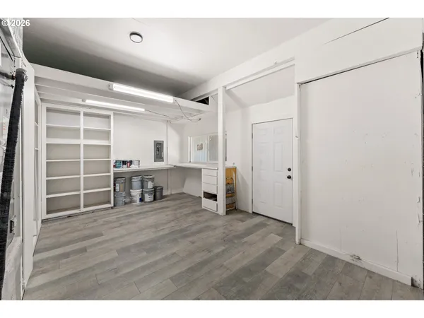 a view of an empty room with wooden floor and a cabinet