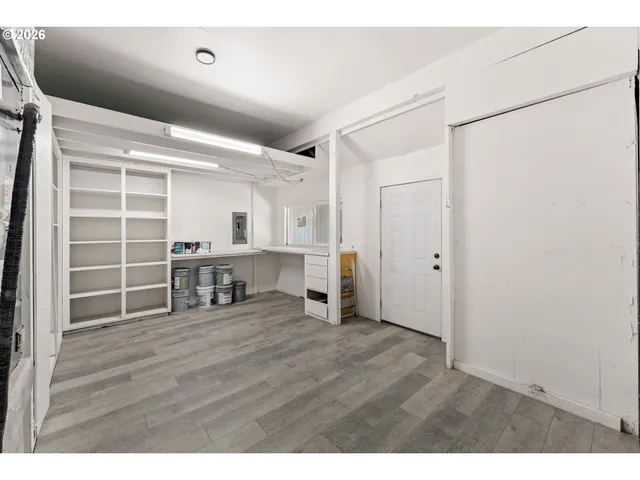 a view of an empty room with wooden floor and a cabinet