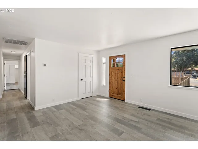 a view of an empty room with wooden floor