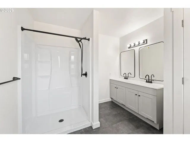 a bathroom with a double vanity sink mirror and shower