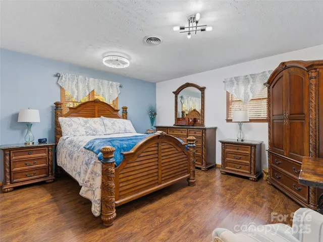 a bedroom with a bed and dresser with mirror