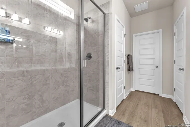 a bathroom with a double vanity sink a mirror and a shower