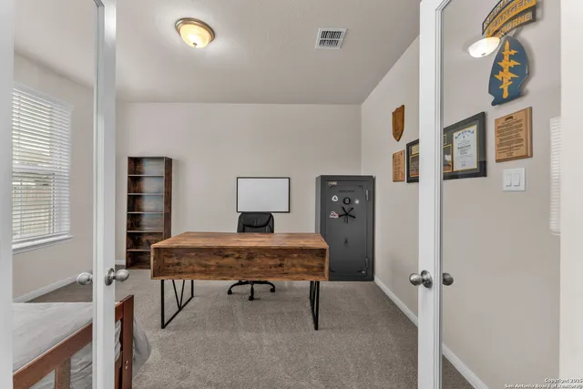 a view of a workspace with furniture and a window