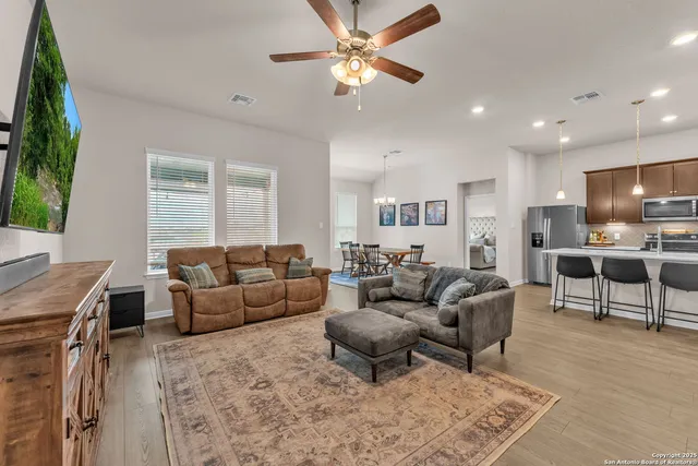 a living room with furniture and a dining table with kitchen view