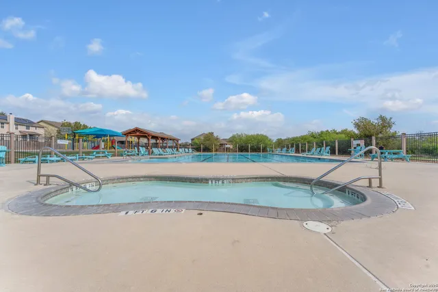 a view of a swimming pool with lawn chairs under an umbrella