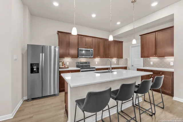 a large kitchen with stainless steel appliances a stove center island a refrigerator and a center island