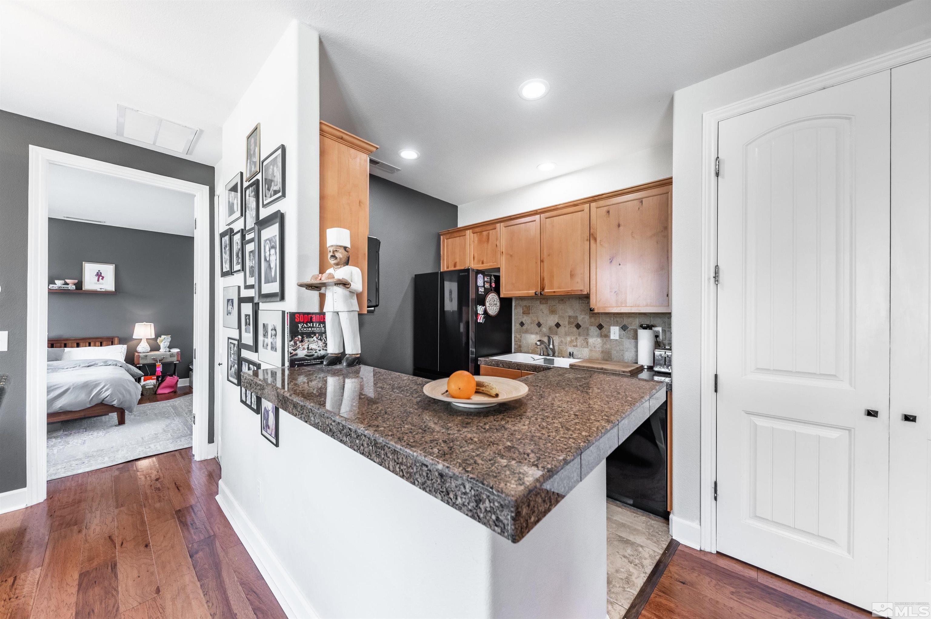 3677 Warren Way, Unit C Reno, NV 89509 - Photo 7 of 23 a view of kitchen island with stainless steel appliances granite countertop living room and wooden floor