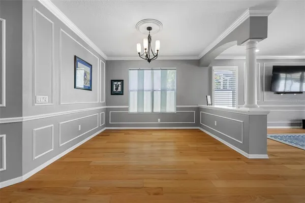 a view of an empty room with a window and wooden floor