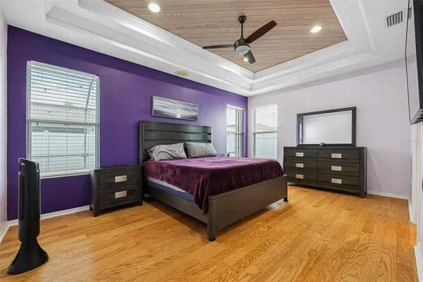 a bedroom with a bed dresser and a flat tv screen