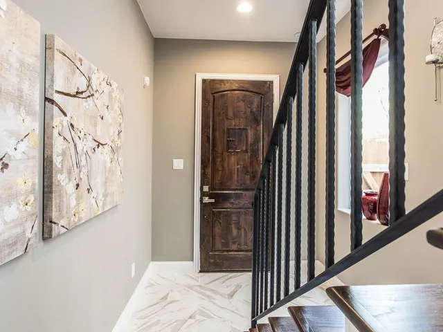 a view of a hallway with wooden floor and stairs