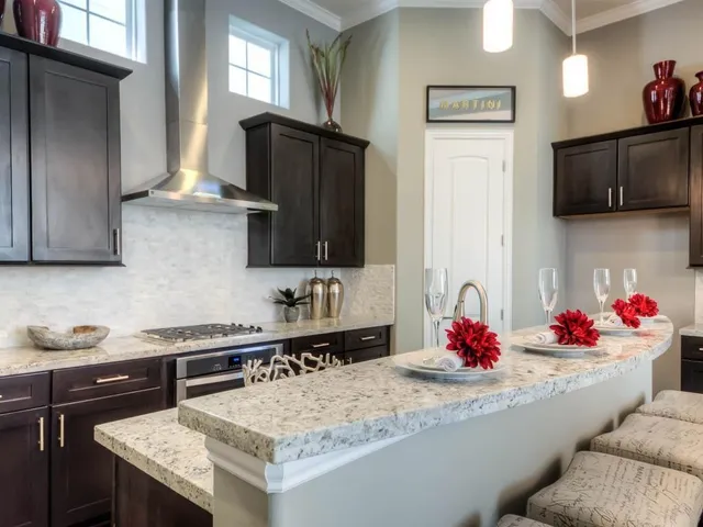 a kitchen with stainless steel appliances kitchen island granite countertop a sink dishwasher and cabinets with wooden floor