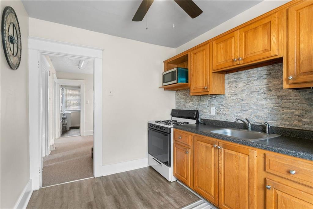 425 Braddock Road Pittsburgh, PA 15221 - Photo 19 of 39 a kitchen with stainless steel appliances granite countertop a sink a stove cabinets and entryway