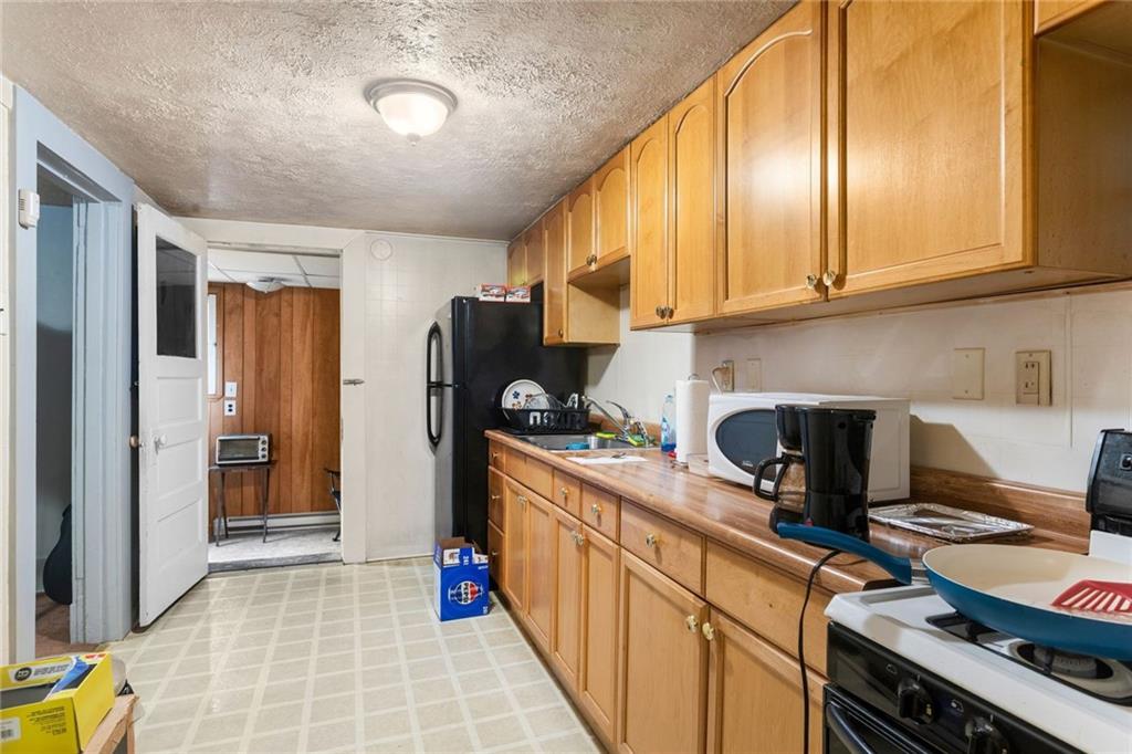 425 Braddock Road Pittsburgh, PA 15221 - Photo 27 of 39 a kitchen with stainless steel appliances granite countertop a stove and a refrigerator
