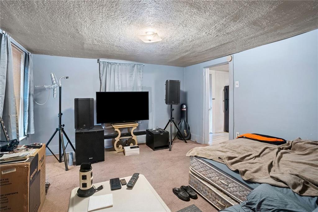 425 Braddock Road Pittsburgh, PA 15221 - Photo 29 of 39 a bedroom with a bed and a flat screen tv