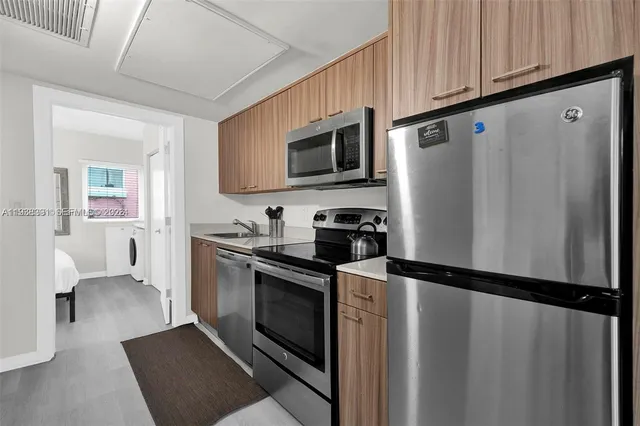 a kitchen with stainless steel appliances a refrigerator sink and microwave