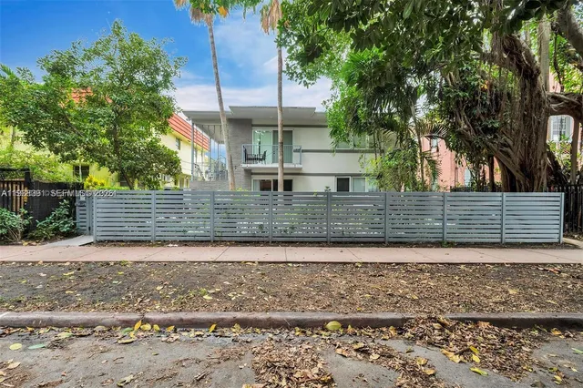 a view of a yard with plants and trees