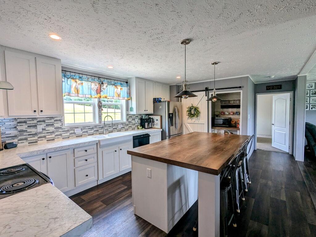 515 Windsor Road Northwest Willis, VA 24380 - Photo 22 of 30 a kitchen with stainless steel appliances granite countertop a kitchen island a stove and a sink