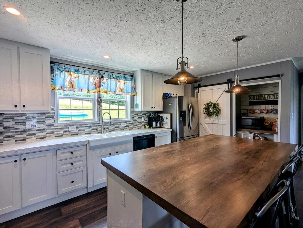 515 Windsor Road Northwest Willis, VA 24380 - Photo 6 of 30 a kitchen with granite countertop a stove a sink a refrigerator and a wooden cabinets