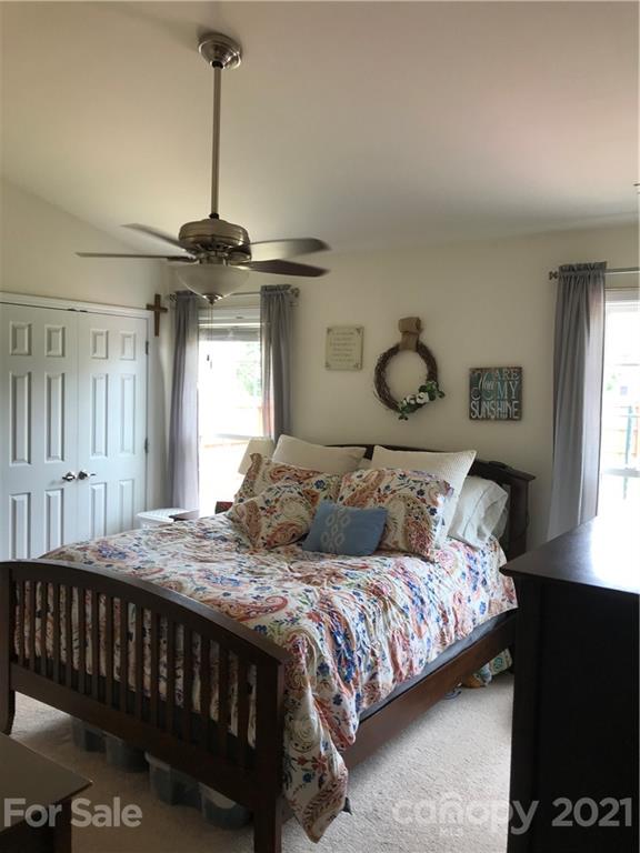 189 Pamlico Road Fletcher, NC 28732 - Photo 5 of 12 a bedroom with a bed window and a chandelier