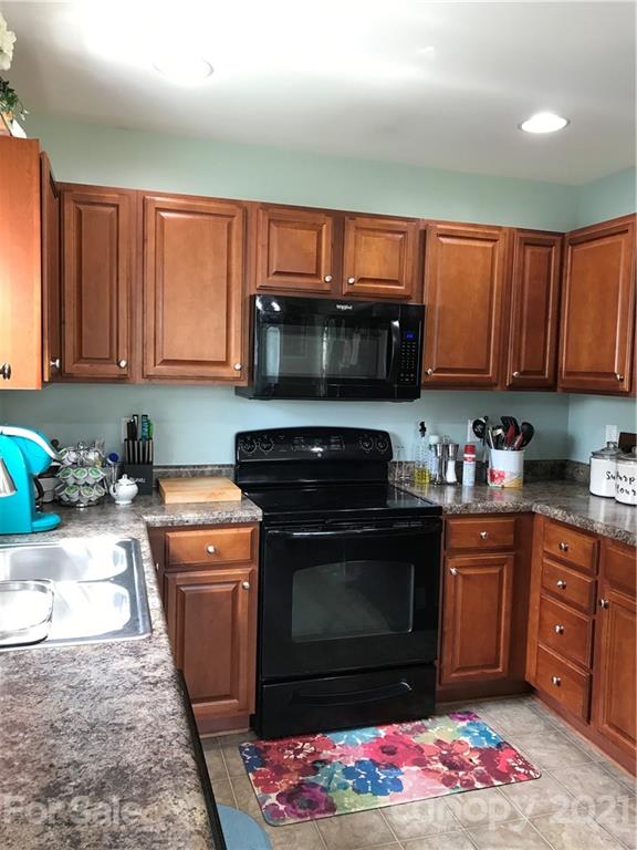 189 Pamlico Road Fletcher, NC 28732 - Photo 10 of 12 a kitchen with stainless steel appliances granite countertop a stove top oven a sink and a microwave