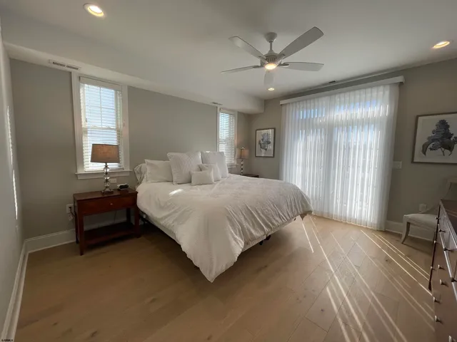 a spacious bedroom with a large bed and a chandelier