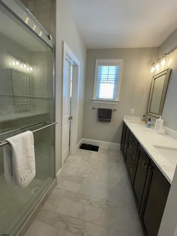 a bathroom with double vanity and a mirror