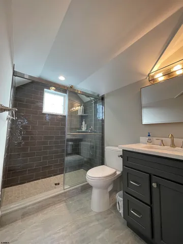 a bathroom with a sink toilet a mirror and shower