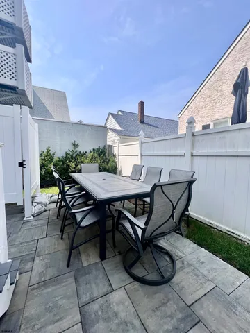a view of a patio with table and chairs with wooden floor and plants