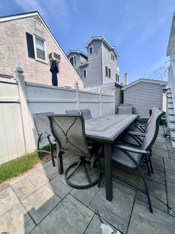 a view of a patio with table and chairs with wooden floor and fence