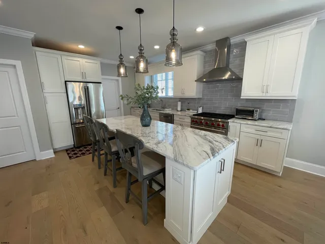 a kitchen with kitchen island a counter top space appliances a sink and cabinets