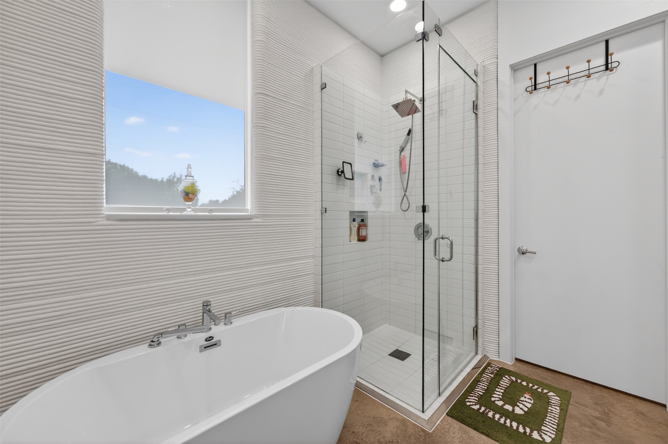308 Painted Sunset Drive Georgetown, TX 78628 - Photo 25 of 26 Freestanding soaking tub with chrome fixtures, glass-enclosed shower with subway tile surround, textured wall tile, recessed lighting, and a window with roller shade